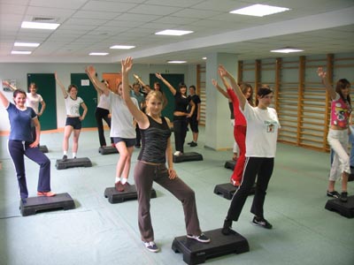 A group of students exercising on steppers
