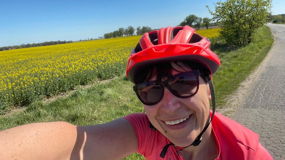 The selfie shows a person wearing a helmet against a field background