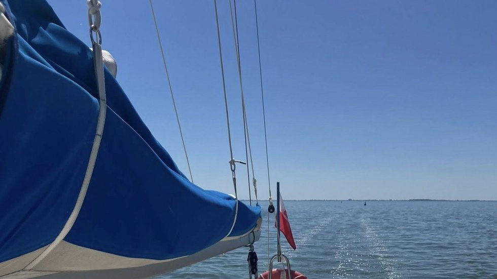 Zdjęcie żagla jachtu podczas rejsu po spokojnej wodzie