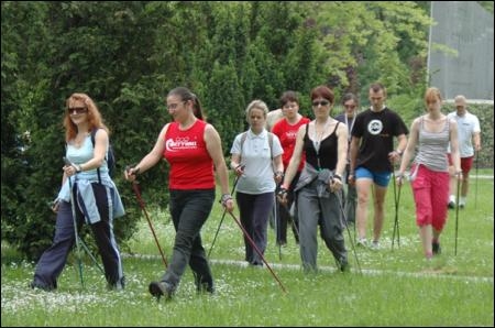 [Translate to English:] Grupa studentów trenująca nordic walking przed budynkiem CWFiS