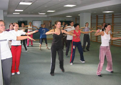 A group of students imitating the movements of the teacher