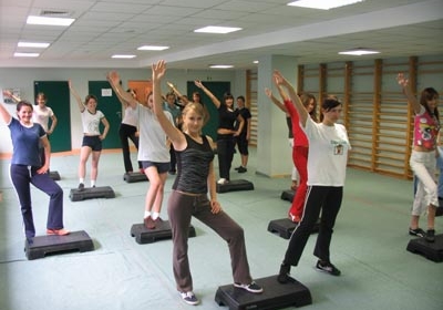 A group of students exercising on steppers